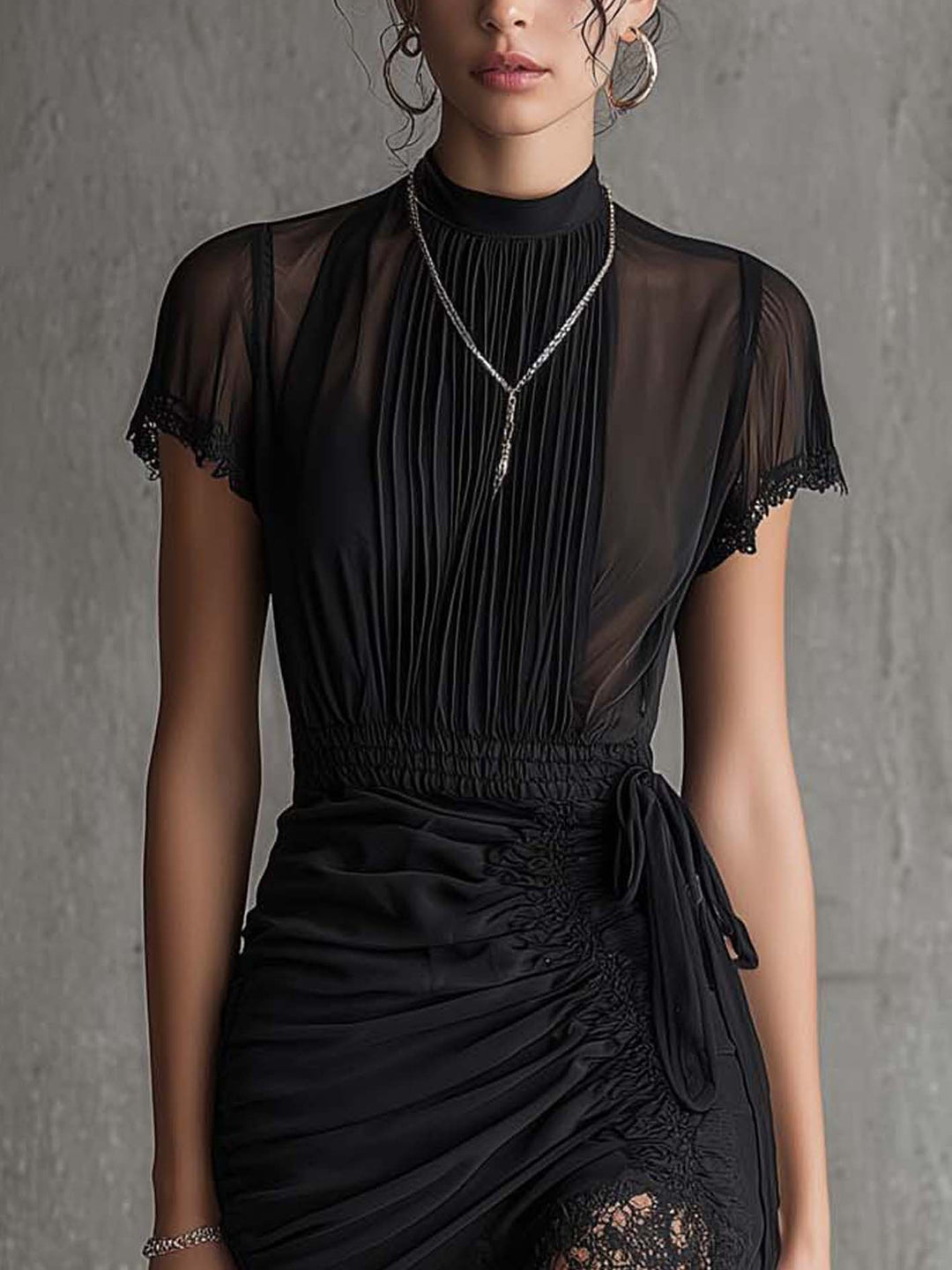 Mini-robe noire plissée à la taille et bordée de dentelle