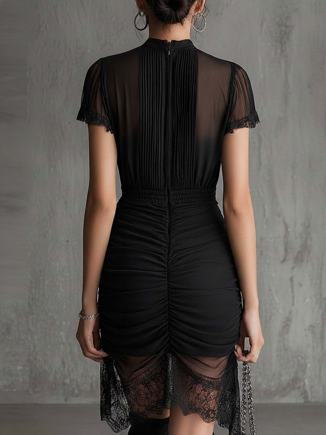 Mini-robe noire plissée à la taille et bordée de dentelle